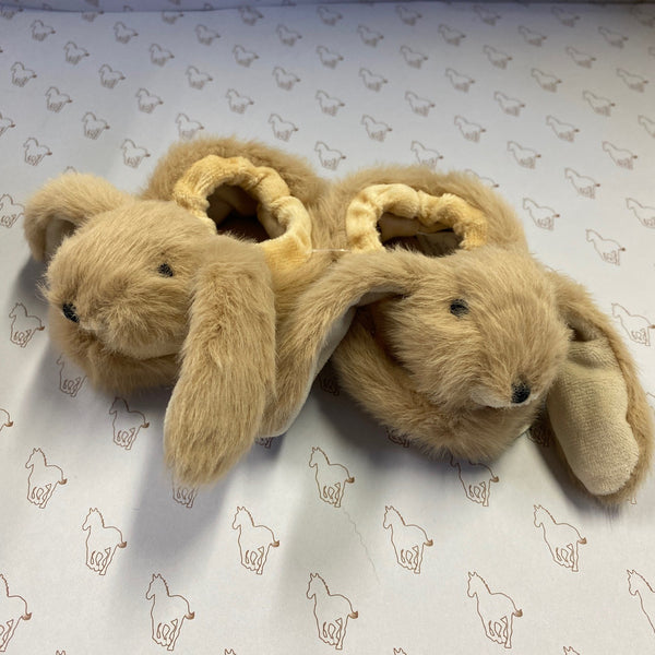 Pair of plush bunny slippers on a patterned surface