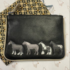 A small black leather coin purse with zip top opening. Four black and white horses are stitched on the front. 