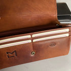 A tan leather purse shown open, with a zip opening pocket inside and four card slots at the front.